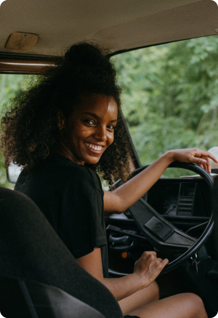 A smiling driver looking back from the wheel